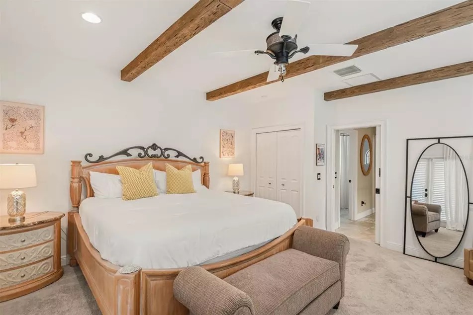 The primary suite at 221 Minnehaha, with tall windows, neutral palette, and back-porch access